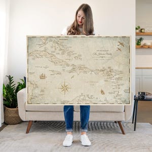 May include: A rectangular wall map of the Caribbean Sea featuring a vintage-style beige background with dark brown text and illustrations. The map displays islands, a compass rose, a sailing ship, and birds, with the text The Travels of The Johnson Family.