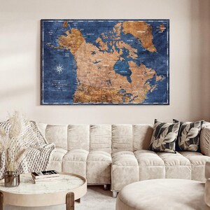 May include: A rectangular wall map of Canada featuring a wood-grain texture in shades of brown against a deep navy blue background. The map displays geographical details, including provinces, territories, and bodies of water, with a compass rose.