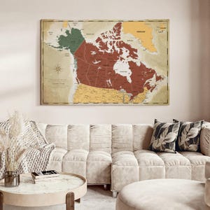 May include: A rectangular wall map print featuring a vintage-style aesthetic with a muted color palette. The map highlights Canada in a deep rust red, with surrounding regions in muted green and yellow tones, including a compass rose and text.