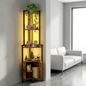 May include: A corner shelf unit with a dark metal frame and wooden shelves. The shelves are decorated with miniature Christmas village houses, a Christmas tree, and a Santa Claus figurine. A green plant sits on top. The unit has a built-in light.