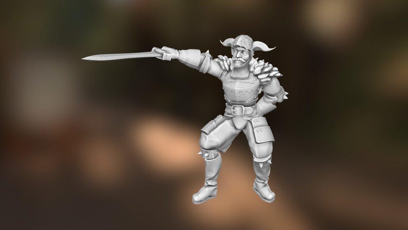 May include: A gray figurine of a warrior in armor, holding a sword. The figure has a helmet with horns and is posed in a dynamic stance. The armor includes shoulder pads and knee guards, and the figure is wearing boots. The background is blurred.