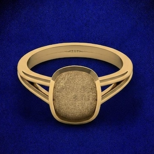 May include: A gold ring featuring a split shank design and a central, rounded square setting. The face of the setting has a textured, matte finish, while the band and the edges of the setting display a smooth, polished gold surface.