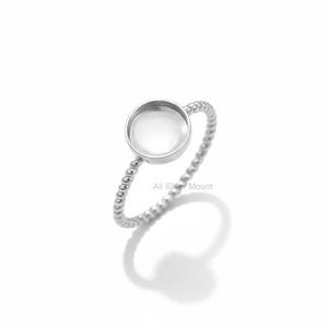 Puede incluir: Un anillo plateado con un engaste redondo y una banda trenzada. El anillo está hecho de un metal brillante y se encuentra sobre un fondo blanco. El texto "All Silver Mount" es visible en el anillo.