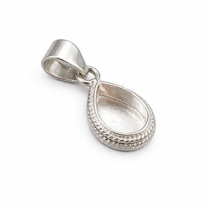 May include: A silver pendant with a teardrop-shaped bezel. The bezel has a rope-like border and a loop for a chain. The pendant's bail is a simple, curved design.