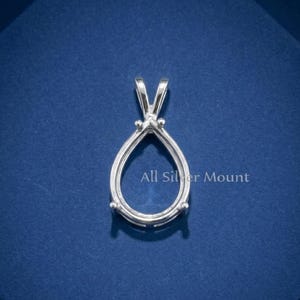 May include: A silver-colored pear-shaped pendant setting featuring a central open frame for a gemstone, three small prongs for securing a stone, and a triangular bail at the top. The text All Silver Mount is printed in white on the surface.