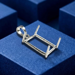 May include: A silver-toned metal pendant setting featuring a rectangular frame with four upright prongs at the corners and a circular bail at one end, designed to hold a gemstone in a secure, open-back mounting for jewelry creation.