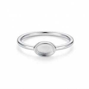 May include: A silver ring with a round, bezel-set centre. The ring band is smooth and polished. The centre setting is designed to hold a stone or other decorative element. The ring is shown against a white background.