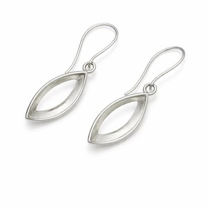 May include: A pair of silver-colored earrings. Each earring features a teardrop-shaped open design with a hook closure. The earrings are displayed on a white background, highlighting their minimalist and modern aesthetic. The earrings are a jewelry item.