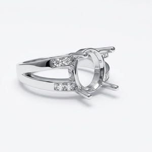 May include: A silver ring with an oval setting, featuring a split shank design. The ring is adorned with small, clear gemstones set along the band, adding sparkle. The ring is set against a white background.