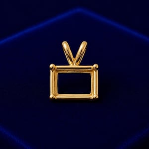 May include: A gold-toned rectangular pendant setting featuring a smooth, polished finish with four rounded corner prongs and a V-shaped bail at the top, designed to hold a gemstone in a horizontal orientation with an open center frame.