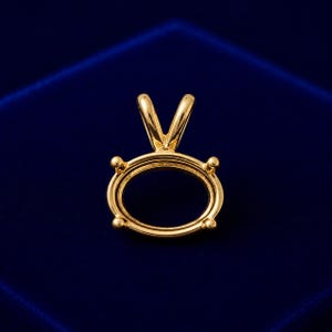 Peut inclure: Un pendentif en or poli doté d'une monture ovale avec quatre petites griffes conçues pour maintenir une pierre précieuse. La pièce comprend une bélière en forme de V sur le dessus pour l'attacher à une chaîne, avec une finition métallique lisse.