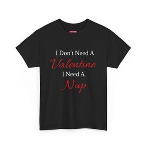 May include: Black t-shirt with the text "I Don't Need A Valentine I Need A Nap" in white and red lettering. The shirt is a crew neck style.