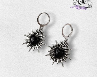 Brincos de argola Sagrado Coração - pretos: argolas em aço inoxidável com pingentes de coração sagrado em liga de zinco representando raios de sol.