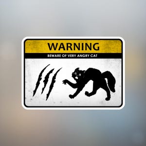 May include: A rectangular sticker with a yellow top section that reads "WARNING" in bold black letters. Below, it says "BEWARE OF VERY ANGRY CAT". A black silhouette of an angry cat is on the right, with claw marks on the left.