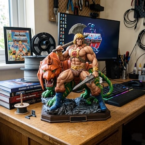 May include: A detailed resin statue of a muscular blonde warrior holding a silver battle axe and a short sword, standing atop a green and orange tiger figure on a rocky base. The figure wears a brown chest harness, gold wrist cuffs, and blue boots.