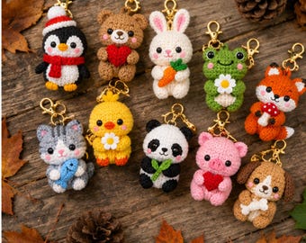 May include: A collection of ten crocheted animal keychains, including a penguin, bear, rabbit, frog, fox, cat, chick, panda, pig, and dog, each featuring a gold-toned metal lobster clasp and holding a small accessory like a heart, carrot, or flower.