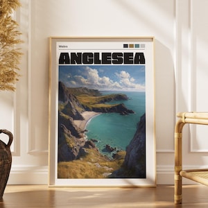 Puede incluir: Una impresión enmarcada que presenta un paisaje costero de Anglesea, Gales, con la palabra "ANGLESEA" en letras negras en negrita. La obra de arte representa un mar turquesa, una playa de arena y acantilados escarpados bajo un cielo azul. El marco es dorado.