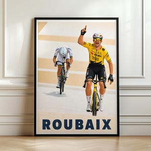 May include: A framed poster featuring a professional cyclist in a yellow jersey celebrating with one arm raised while riding a yellow bicycle, followed by another cyclist in white gear on a track, with the word ROUBAIX printed in bold blue letters.