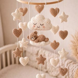 Könnte beinhalten: Handgefertigtes Baby-Mobile aus Häkelarbeit mit Holzring, cremefarbenen, braunen und beigen Sternen, Herzen und einer Wolke mit einem schlafenden Teddybären. Dekoration für das Kinderzimmer.