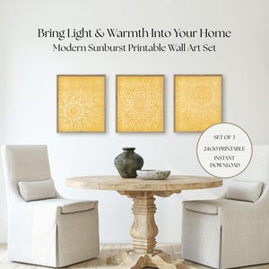 May include: Three framed yellow sunburst art prints hang above a round wooden table with a vase and bowl. Two upholstered chairs flank the table. The text reads "Bring Light & Warmth Into Your Home" and "Modern Sunburst Printable Wall Art Set."