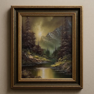 Può includere: Dipinto di paesaggio incorniciato che raffigura una serena scena di montagna con un fiume che riflette la luce del sole. L'opera d'arte presenta una cornice ornata verde scuro e oro. Il dipinto mostra una foresta con alberi alti, un fiume e montagne sullo sfondo, con una calda luce dorata.