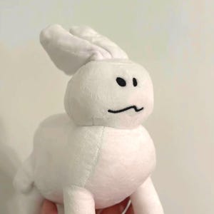 May include: A white plush bunny toy with black eyes and a curved mouth. The stuffed animal has long ears and is made of soft, fuzzy material. The bunny is a cute and cuddly toy.