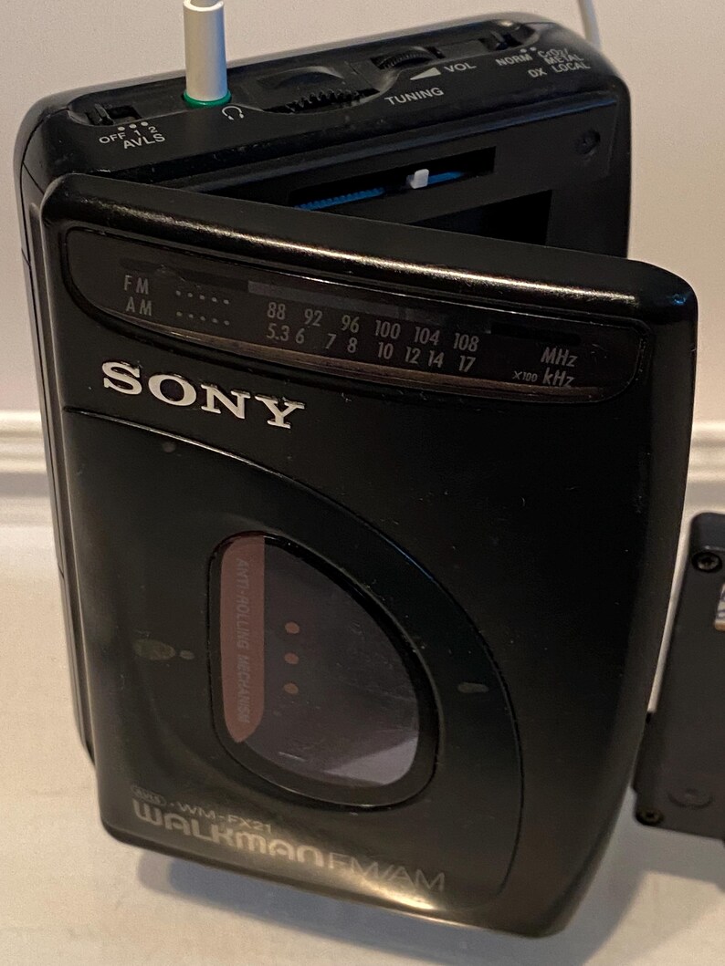 May include: Black Sony Walkman FM/AM radio with a silver headphone jack. The radio has a tuning dial, volume control, and frequency display. The model number is WM-FX21.