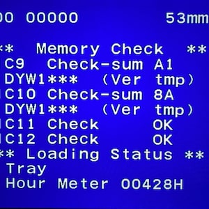 May include: A blue screen displays technical data. Text includes "Memory Check," "Check-sum," and "Loading Status." The screen also shows "53mm" and a reading of "Hour Meter 00428H."