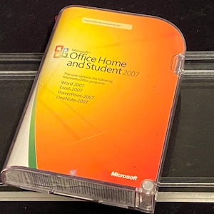 May include: Microsoft Office Home and Student 2007 software in a clear plastic case. The cover is orange and yellow with the Microsoft logo and software titles: Word, Excel, PowerPoint, and OneNote.