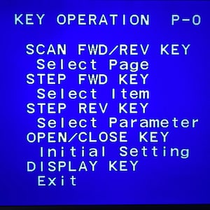 May include: A blue screen displays white text detailing key operations. The text includes commands like 'SCAN FWD/REV KEY', 'Select Page', 'STEP FWD KEY', and 'Exit'. The image is a close-up of the screen.
