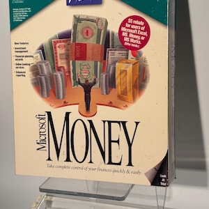 May include: A Microsoft Money software box featuring a central illustration of a person standing before a stack of currency, coins, and a gold bar. The box includes the text Microsoft Home, Microsoft Money, and Take complete control of your finances quickly & easily.