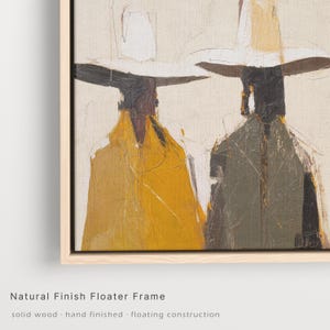 Op de afbeelding: Abstract schilderij in een floater frame met natuurlijke afwerking. Het kunstwerk toont twee figuren met hoeden en jassen in tinten geel, grijs en wit tegen een neutrale achtergrond. Het frame is van massief hout.