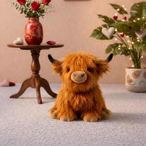 Puede incluir: Una taza de cerámica blanca con un asa negra y el texto "But First, Coffee" en negro, con una fuente de estilo manuscrito. La taza está sobre una superficie blanca.