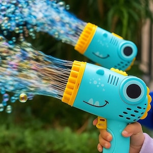 Puede incluir: Se muestran dos pistolas de burbujas azules y amarillas, cada una con un diseño de cara de dinosaurio sonriente. Las pistolas están rociando un chorro de burbujas de colores. El fondo es un verde borroso.
