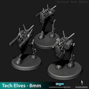 May include: Three gray Tech Elves 8mm walkers, each mounted on a circular base. The walkers have a futuristic design with multiple weapon attachments and are posed in a dynamic stance. The text "Tech Elves - 8mm" is at the bottom.
