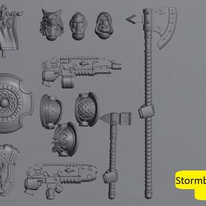 Può includere: Una collezione di accessori in miniatura grigi stampati in 3D, tra cui uno stendardo, una testa di lupo, teste umane, scudi, pistole, asce e un martello. Il testo "Stormbringer Bits" è in un rettangolo giallo.