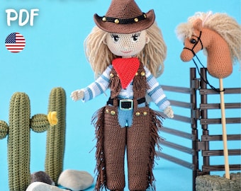 May include: A crocheted doll dressed as a cowgirl, wearing a brown hat, vest, and pants with fringe. The doll has blonde hair and a red bandana. The image includes the text "PATTERN PDF" and a small American flag. A crocheted cactus and a toy horse are also in the image.