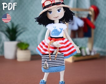 May include: A crochet doll with black hair wearing a beige hat with red glasses, a white t-shirt with a blue whale graphic, a red and white striped skirt, and blue sneakers. The doll carries a black and white striped bag with a sailboat charm.
