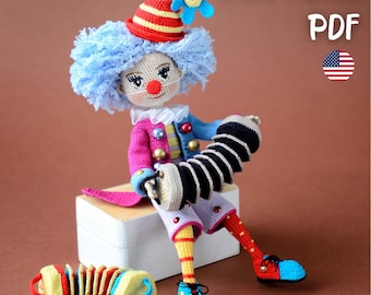 May include: A handmade crochet clown doll with a blue wig, red nose, and colorful outfit. The doll is holding a black and white accordion and wearing red and blue shoes. The text "PATTERN PDF" is visible in the image.