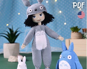 May include: A handmade crochet doll wearing a gray Totoro-inspired outfit, complete with a hat and jumpsuit. A small white bunny and a blue Totoro plushie are also present. The image includes the text "PATTERN PDF" and an American flag.