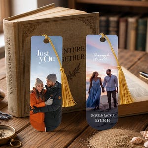 May include: Two rectangular bookmarks with rounded tops and gold tassels. The left bookmark features a couple in winter gear and the text "Just you". The right bookmark shows a couple on a beach with the text "Through it all", "ROSE & JACKIE", and "EST.2016".