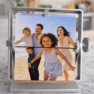 Thoughtful gift mom: Silver rotating metal photo display showing a family beach picture. Personalized freestanding desk frame.