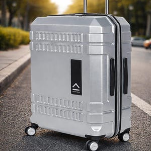 Peut inclure: Valise roulante argentée avec poignée rétractable et détails noirs. La valise a une forme rectangulaire avec une surface texturée et quatre roues. Le mot "uppercase" est imprimé sur la valise.