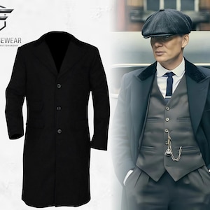 Può includere: Un cappotto lungo nero in lana con chiusura a tre bottoni e due tasche anteriori. Il cappotto è mostrato accanto a un uomo che indossa un cappotto, un gilet e un berretto simili. Il logo Nightforgewear è in alto a sinistra.
