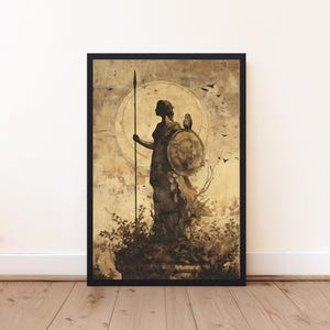 May include: A framed wall art print in sepia tones depicting a silhouette of a figure standing on a stone pedestal. The figure holds a tall spear and a round shield with an owl perched on top. A large circular halo and birds are in the background.