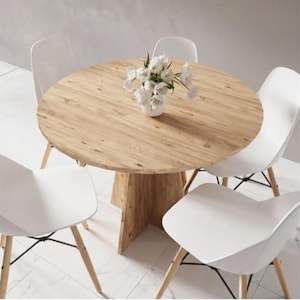 Puede incluir: Una taza de cerámica blanca con un asa negra y el texto "But First, Coffee" en negro, con una fuente de estilo manuscrito. La taza está sobre una superficie blanca.