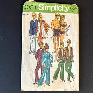 May include: Vintage Simplicity sewing pattern envelope featuring illustrations of various 1960s outfits. The envelope is primarily green and white, with the number 9054 and the price 85¢ printed on it. The illustrations depict a variety of clothing styles.