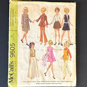 May include: Vintage McCall's 9605 sewing pattern for teen fashion dolls. The pattern features illustrations of various outfits, including coats, pantsuits, dresses, and skirts. The pattern fits a 11.5-inch doll and includes the text "Teen Fashion Dolls' Instant Wardrobe".
