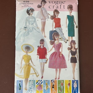 May include: A vintage Vogue Craft pattern featuring doll fashions. The pattern includes illustrations of dolls in various outfits, including a wedding dress, a red and white gingham dress, and a green polka dot dress. The pattern number is 639.