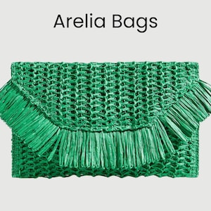 Könnte beinhalten: Eine grüne gewebte Clutch-Tasche mit Fransen. Die Tasche hat eine rechteckige Form mit einem Klappenverschluss. Der Text "Arelia Bags" wird oben im Bild angezeigt.